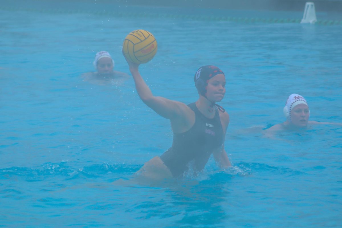 Bulldogs' attacker Charley Stephens raises in the water for a shot attempt against the Indiana Hoosiers in the fog at the Fresno State Aquatics Center.