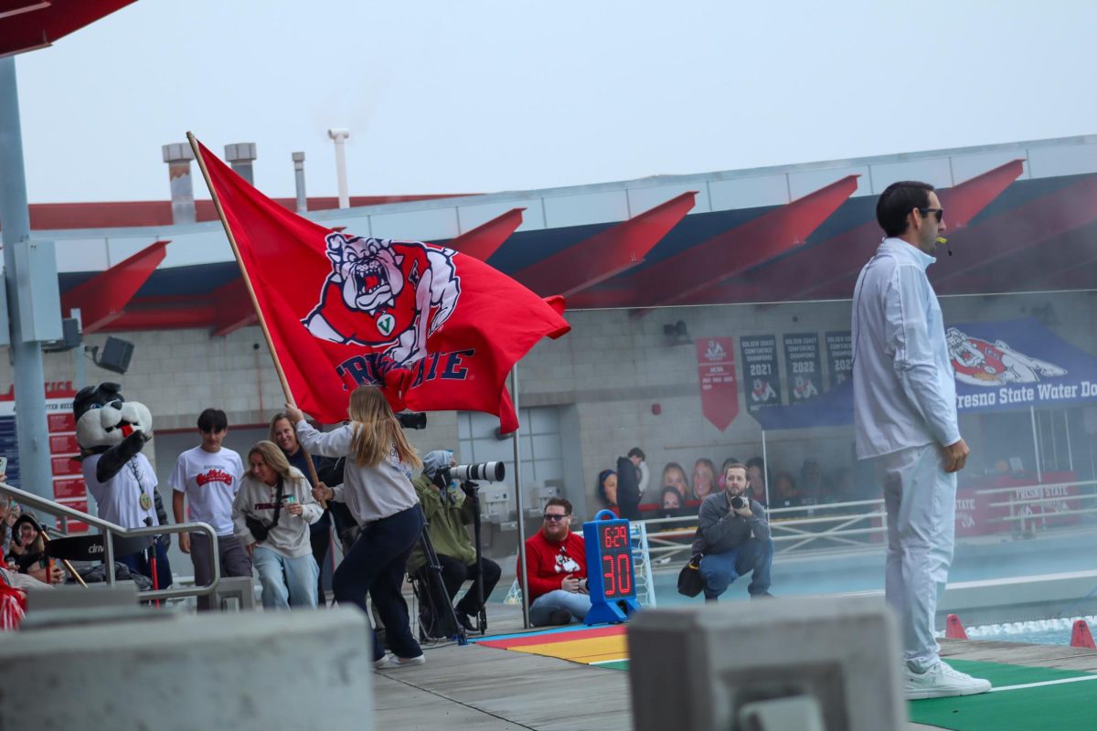 A fan runs with a Fresno State flag in front of the stands at the Fresno State Aquatics center after a Bulldog goal against the Indiana Hoosiers on Jan. 17.