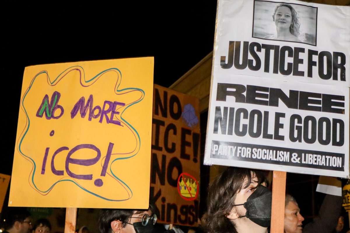 Protesters hold signs at a demonstration in Downtown Fresno on Jan. 8.
