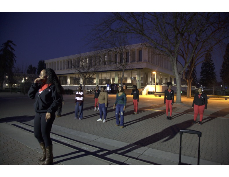 The Red Wavettes dance team coach leads team members and students in a line dance in the Free Speech Area at Fresno State on Feb. 2.