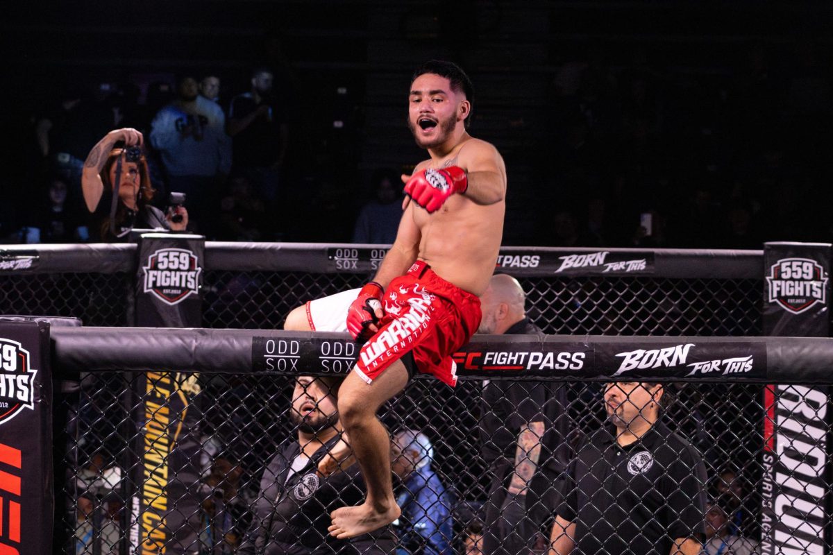 Sajin Zacarias celebrates on the cage after a technical knockout againt Paul Furr on Feb. 13 at the Visalia Convention Center.