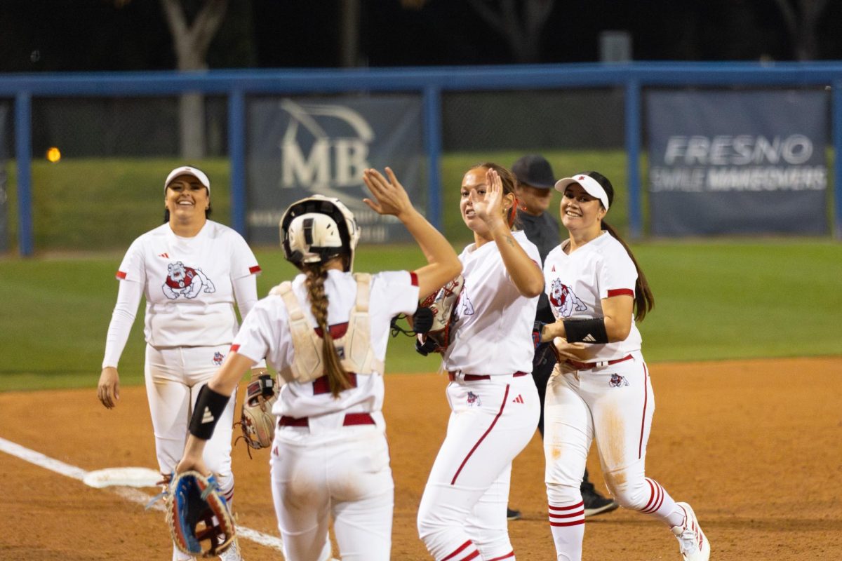 Fresno State softball pitcher Alyssa Loza high fives her catcher, Mackenna Pettey as she walks off the field after collecting her first collegiate strikeout against the Idaho State Bengals on Feb. 6 at Margie Wright Diamond. Loza's first strikeout came with the bases loaded.