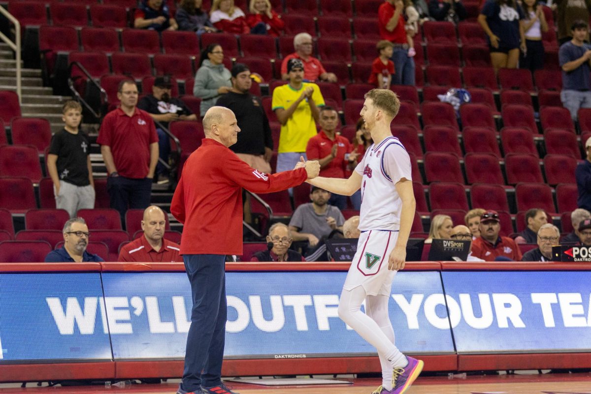 Fresno State men's basketball guard Jake Heidbreder and Head Coach Vance Walberg go in for an embrace as Heidbrder walks off the court for the final time at the Save Mart Center on March 3. 