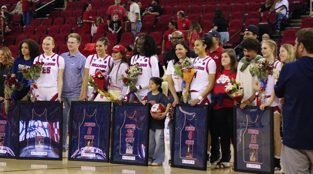 The Fresno State women's basketball seniors smile for a group photo with their supporters and their framed jerseys on Feb. 28 at the Save Mart Center. All six players honored played just one season at Fresno State, but left a lasting impact on the program. 