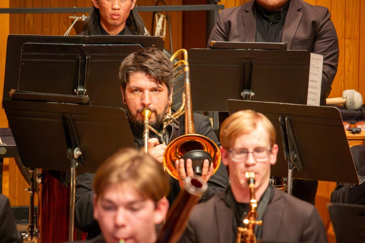 Micah Masterson uses a plunger mute while playing the trombone.