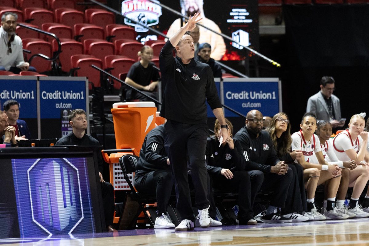 Head Coach Ryan McCarthy signals to his players.