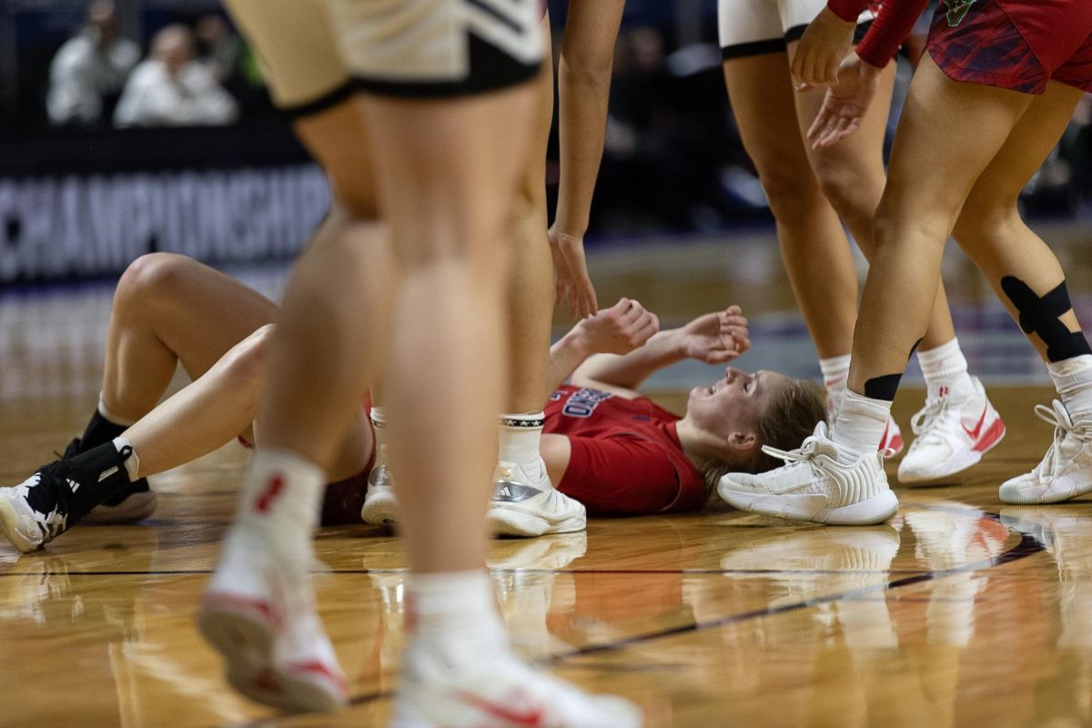 Emilia Long lays on the hardwood after getting fouled.