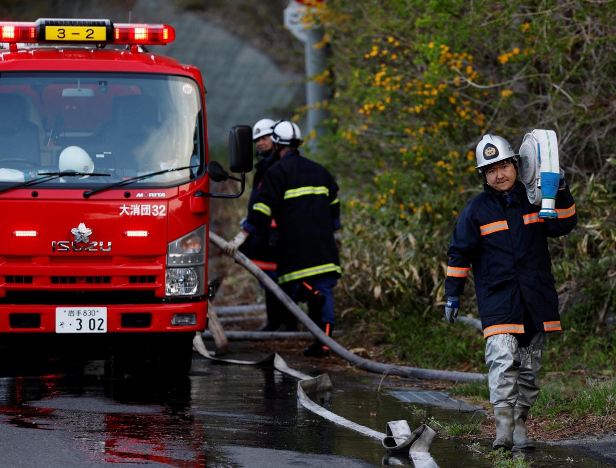 Volunteer firefighter Ryota Haga carries a fire hose to battle a wildfire in Otsuchi, Iwate Prefecture, Japan, April 26, 2026. REUTERS/Kim Kyung-Hoon