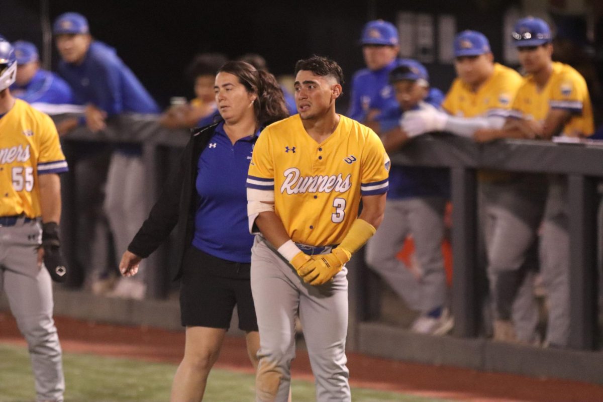 Roadrunner Yahir Acevedo holds his wrist after being hit by a pitch in the fifth inning.