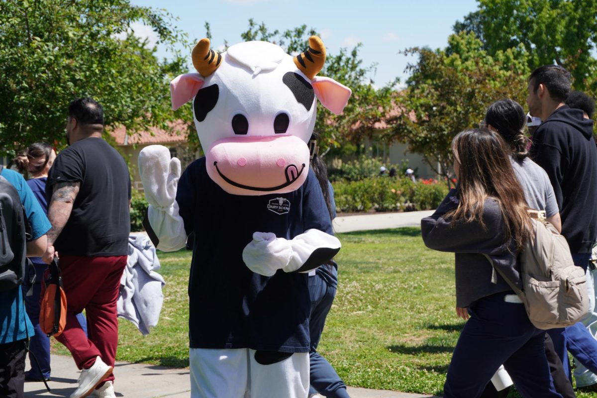 A cow mascot waves "hello" at Dairy Day in the Memorial Gardens on Tuesday.
