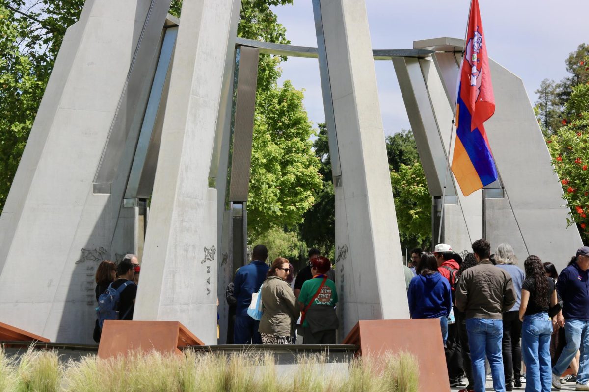 Members attending the afternoon commemoration ceremony approach the center of the monument to lay flowers. 