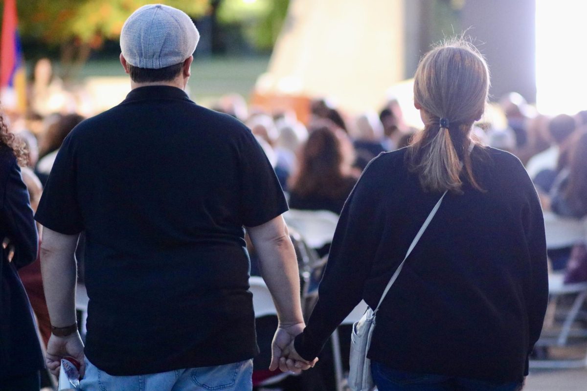 A couple stands united, holding hands, at the Armenian Genocide commemoration ceremony. 