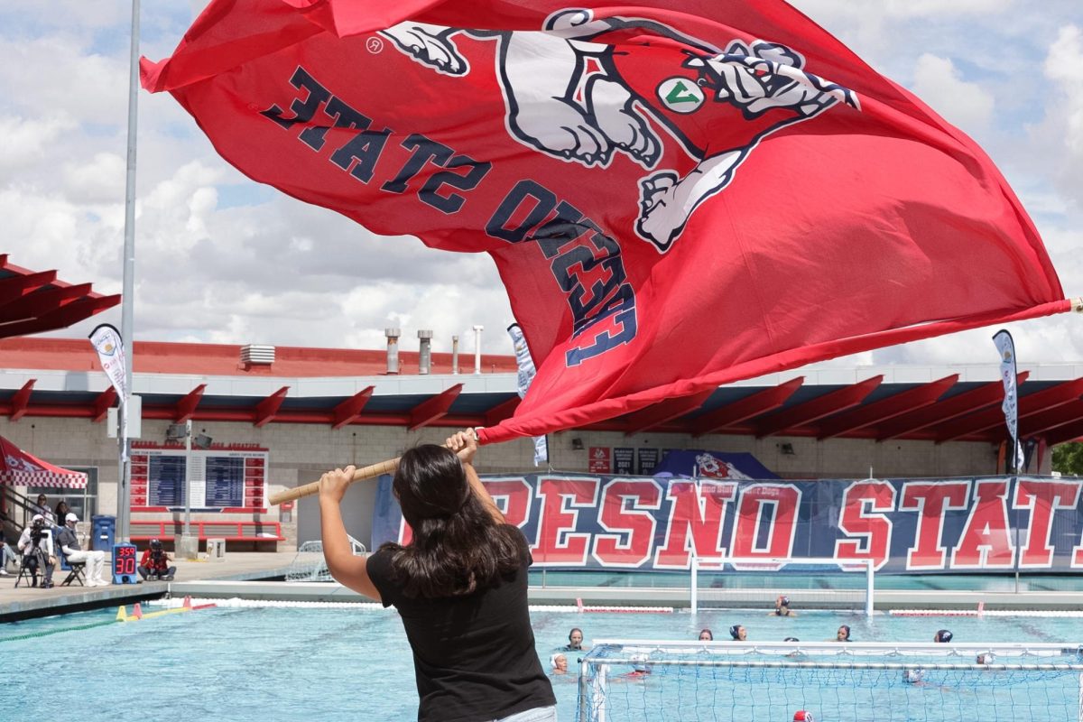 A fan waves a Fresno State flag after a Bulldogs goal on April 11 at the Fresno State Aquatics Center during the GCC Tournament.