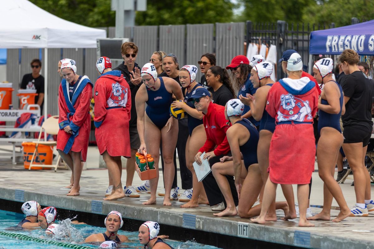 The Fresno State water polo team gathers poolside during a timeout in the GCC Championship game on April 12 at the Fresno State Aquatics Center.