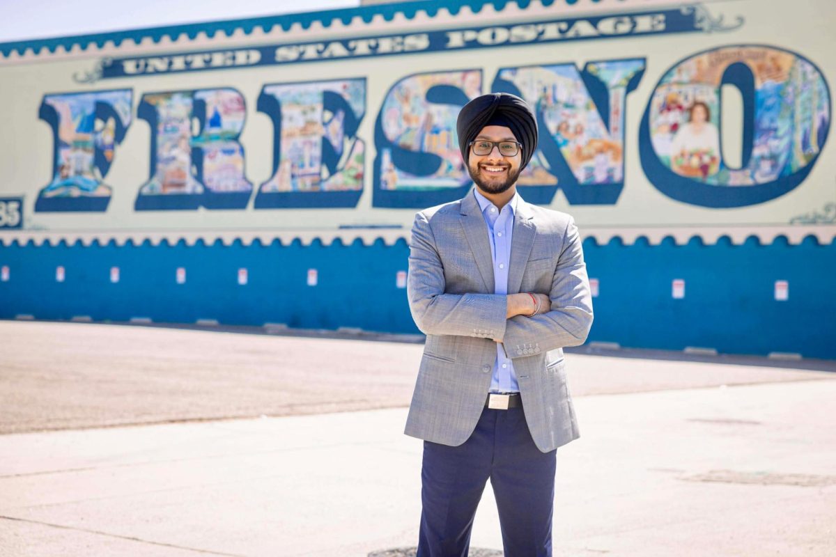 Fresno City Council candidate Navkaran Singh Gurm posing in front of Fresno mural.