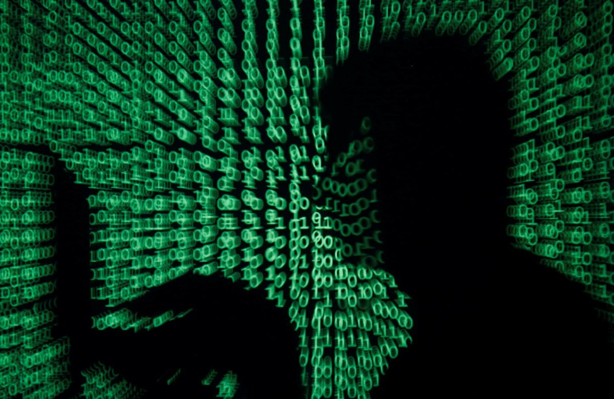 A man holds a laptop computer as cyber code is projected on him in this illustration picture taken on May 13, 2017. Capitalizing on spying tools believed to have been developed by the U.S. National Security Agency, hackers staged a cyber assault with a self-spreading malware that has infected tens of thousands of computers in nearly 100 countries. REUTERS/Kacper Pempel/Illustration