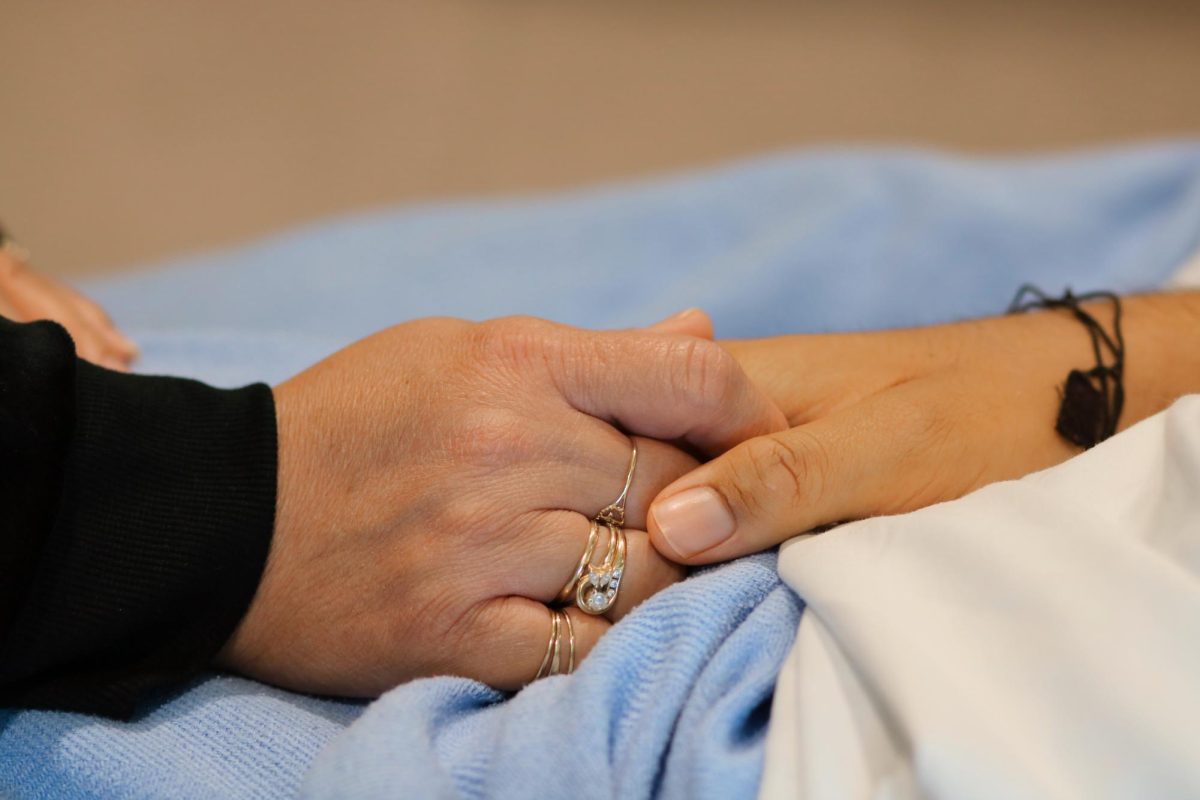 Monica and Joshua hold hands showing love and unity. 