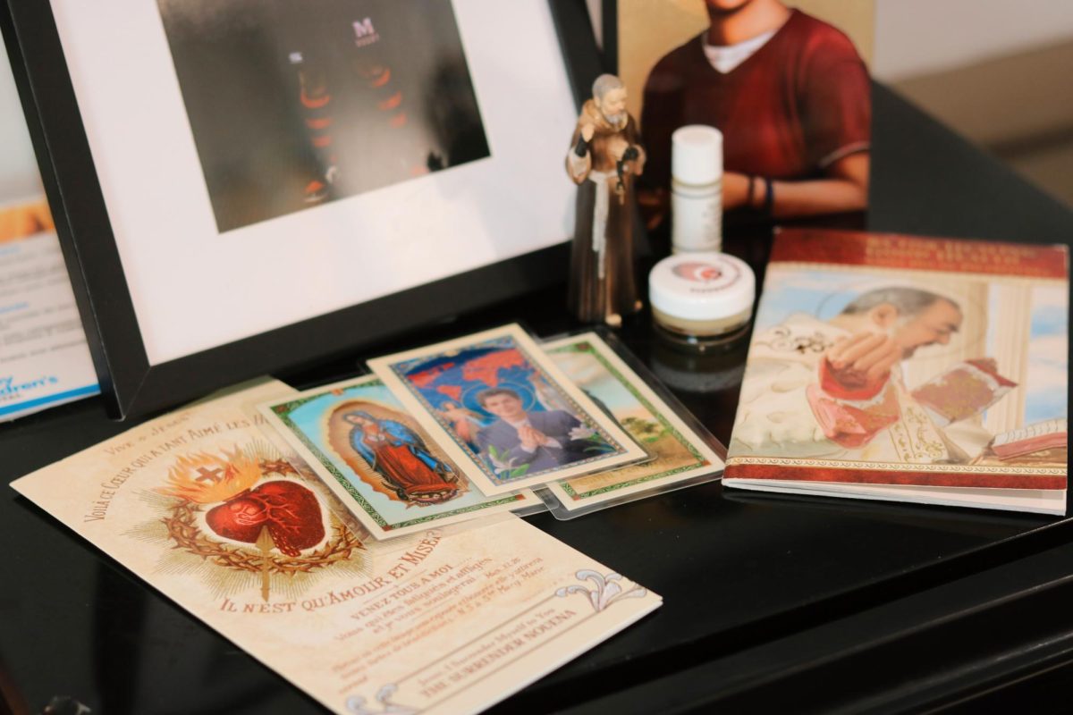 Joshua's table showing the different Catholic saints, cards, booklets and other items in front of his bed. 